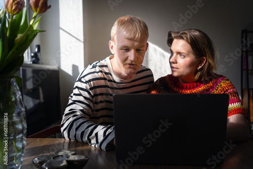 Wallpaper Mural Freelancer couple discussing while working on laptop at home Torontodigital.ca