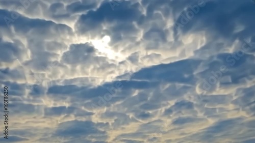 Stunning Sky Canvas: A mesmerizing view of the sun peeking through a dense layer of Altocumulus clouds, creating a breathtaking spectacle of nature's artistry.