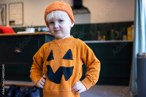 A little boy wearing a homemade pumpkin halloween costume