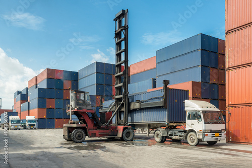 Forklift loading shipping container onto a semi truck