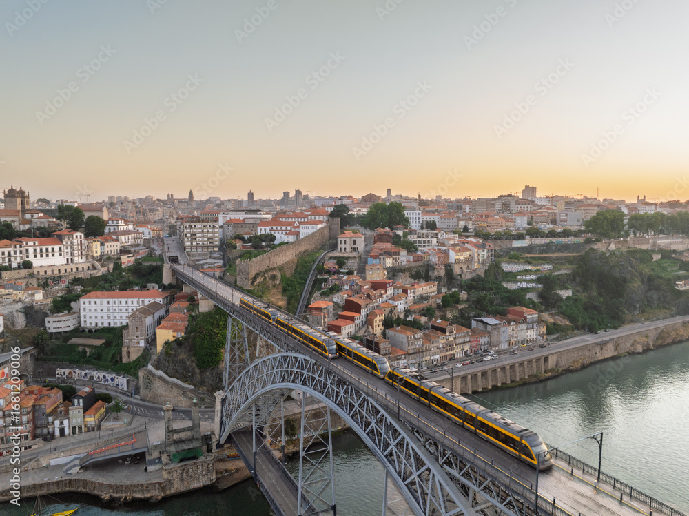 Obraz premium Sunrise View of Porto City, Portugal. Dom Luis I Bridge and Metro Train on It. Drone, Golden Hour