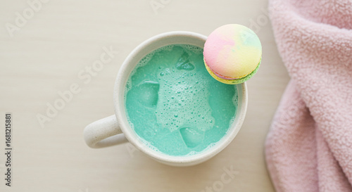 Sip vibrant blue matcha with a pastel macaron, a cozy treat for a relaxing moment