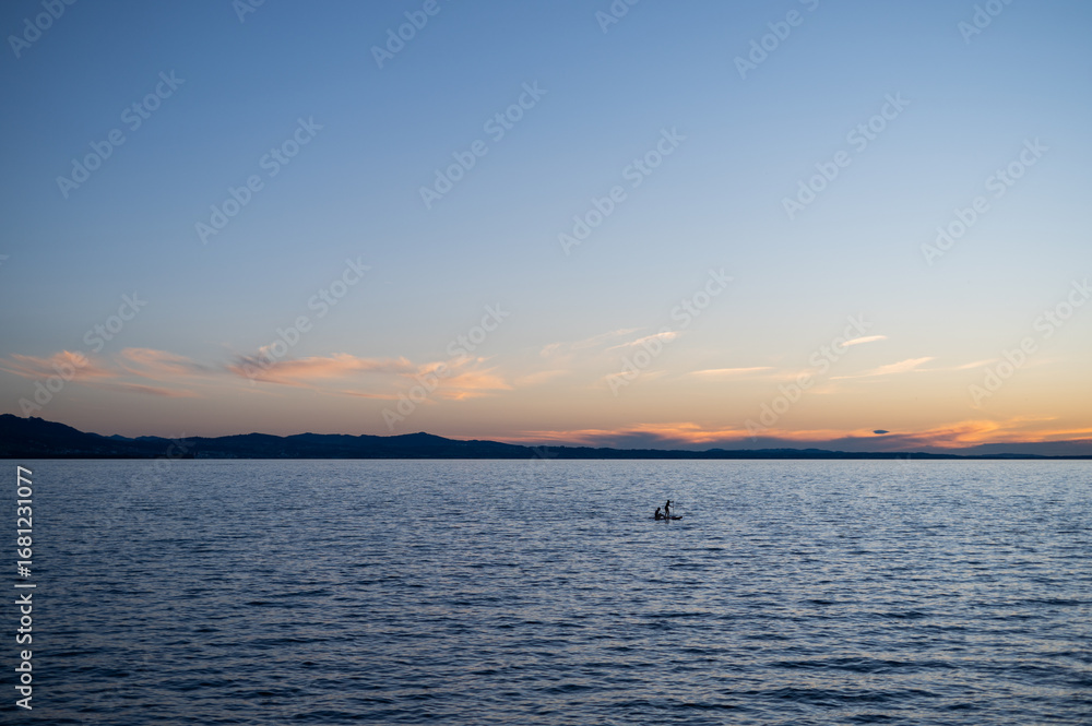 Fototapeta premium Romantic pink sunset over Lake Constance with small boat