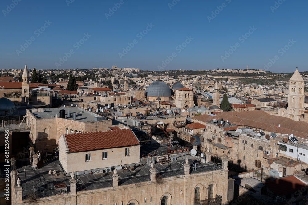 Fototapeta premium View looking east over the Old City of Jerusalem with notable landmarks: Lutheran Church of the Redeemer, Holy Sepulchre Church with its grey cupola and Mt. Scopus in the distance.