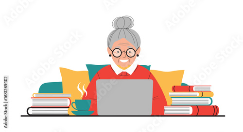 Happy elderly woman with glasses typing on laptop surrounded by books enjoying coffee at home