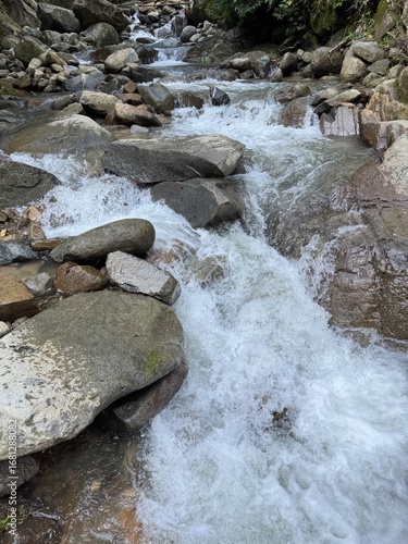 Canvastavla Vibrant rushing mountain stream cascading over smooth rocks, creating a serene natural landscape, perfect for tranquility and nature themes