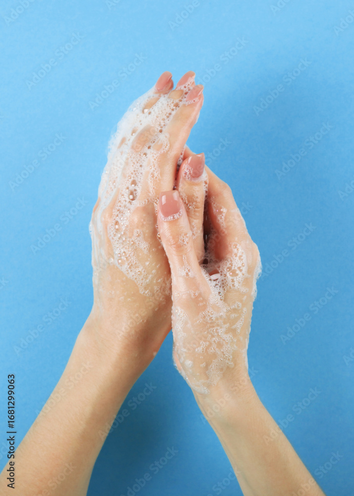 Fototapeta premium girl washes her hands with soap, hygiene and cleanliness of hands. Vertical photo format