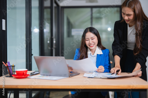  Accountants or business people working together on a project. Two female business colleagues are working on computers.