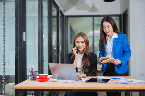  Accountants or business people working together on a project. Two female business colleagues are working on computers.
