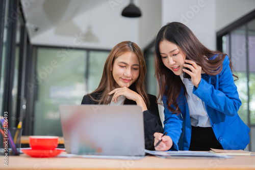 Accountants or business people working together on a project. Two female business colleagues are working on computers.