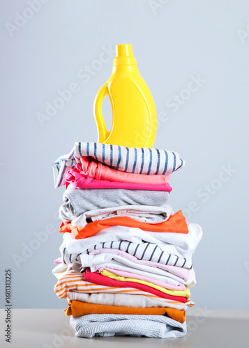 Laundry detergent bottles and clothes on the table. Household chemicals. Vertical photo format