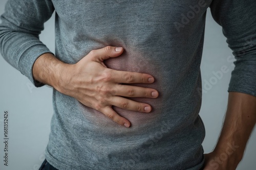 Man clutching his abdomen after overeating fast food, experiencing digestive discomfort or food-related illness.