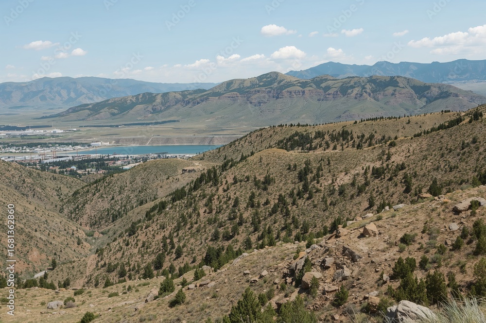 Obraz premium Scenic panorama from a mountain range overlooking a mining operation near a large salt lake during springtime.