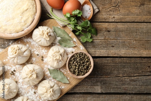 Wallpaper Mural Uncooked khinkalis (dumplings) with peppercorns, flour and bay leaves on wooden table, top view. Space for text Torontodigital.ca