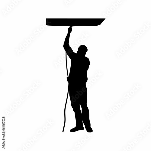 Silhouette of technician installing data cable in office ceiling