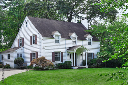 Fotografía Two story clapboard house surrounded by trees
