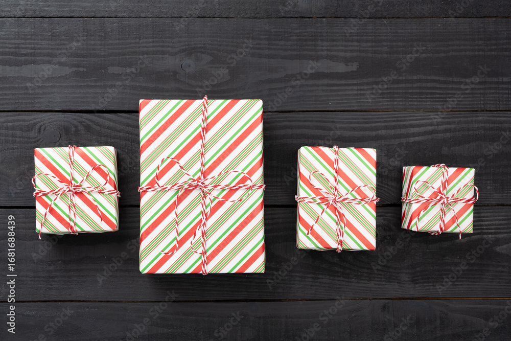Obraz premium Striped Christmas gift boxes on wooden background, top view