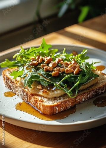 Delicious Open-Faced Sandwich Topped With Greens and Nuts on a Wooden Table i...