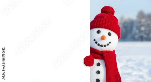 A cheerful snowman wearing a bright red hat and scarf stands beside a blank white sign in a snowy winter scene.
