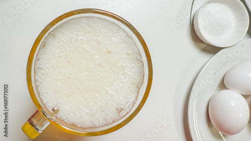 Effervescent froth commands a breakfast rite, invoking World Egg Day and National Foam Party with ethereal culinary whimsy