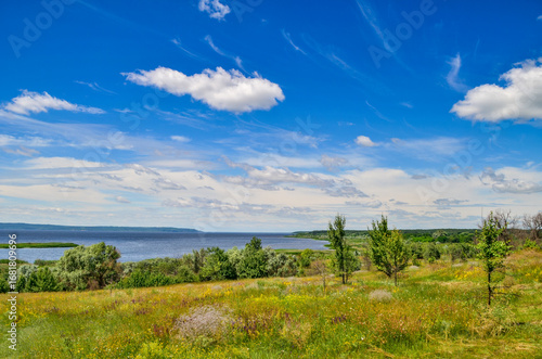 Beautiful summer landscape with clouds on the background of a large river