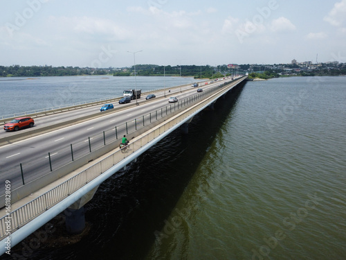 Wallpaper Mural Expansive Bridge Over Calm Waters Connects Distant Cityscape under a Bright Sky ivory coast Torontodigital.ca