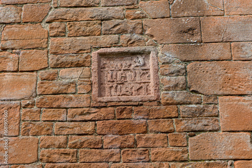фотографія Weathered medieval stone carving on the wall of Brougham Castle ruins in Cumbria