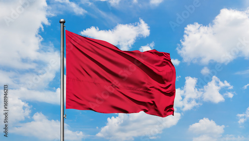 Wallpaper Mural Red Flag Waving Against a Bright Blue Sky with Clouds, Symbol of Freedom and Patriotism Torontodigital.ca