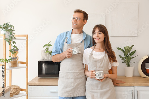 Young couple with aprons an...