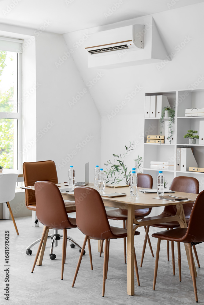 Fototapeta premium Interior of conference hall with table, shelf unit and plants