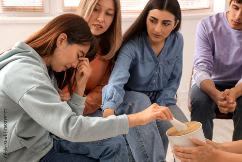 Young woman crying in group...