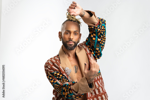 Tableau sur toile Portrait Trendy black latin gay man in fashionable clothes dancing isolated on w
