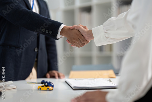 Successful Deal. Business handshake between insurance agent and client over car insurance.