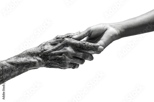 Two hands, old and young, clasped in gentle touch.  A grayscale image of a wrinkled, aged hand reaching out and being clasped by a younger, smoother one, against a black background
