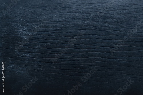 Detailed macro of black leather surface with natural wrinkles. High-quality material background perfect for product mockups, textures, or fashion-related designs.