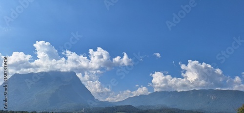 Majestic mountain landscape with blue sky and white clouds scenic background