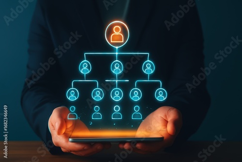 A glowing organizational chart hovers over a tablet, showcasing a hierarchical structure of people.
