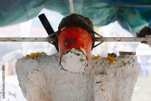 Wallpaper Mural A close-up shot of a crucible containing what appears to be molten metal, held by a long handle, suggesting a process of casting or smelting. Torontodigital.ca