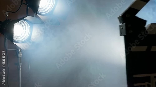 Action! Professional film clapperboard illuminated by dramatic stage lights and smoke creating cinematic atmosphere