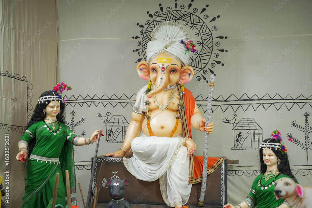 Fototapeta premium Tribal style Ganesh idol, Artistic Ganesha with village women, Traditional Ganpati decoration, Cultural Ganesh festival statue Stock Photo.