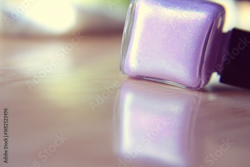 Close-up of iridescent lavender nail polish bottle on reflective surface