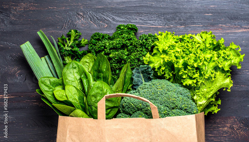Fresh green vegetables in paper bag on dark wood fresh produce healthy eating