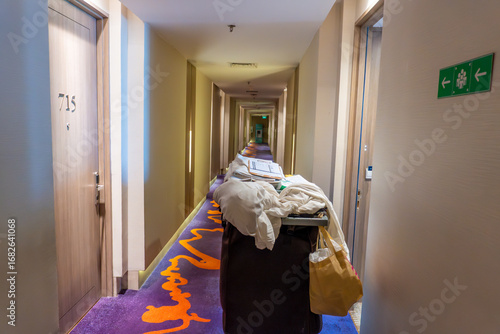 Hotel corridor with housekeeping cart and purple patterned carpet