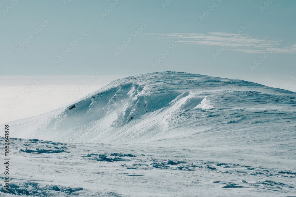 Fototapeta premium Snow-covered mountain peak under a pale sky