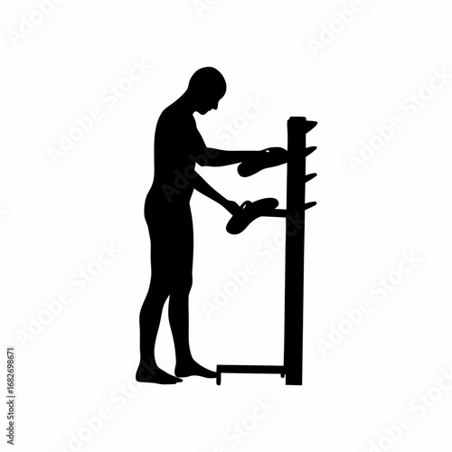 Silhouette of a person placing shoes on a rack isolated on white