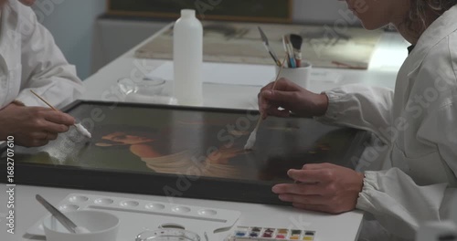 Painting conservators restoring a famous artwork