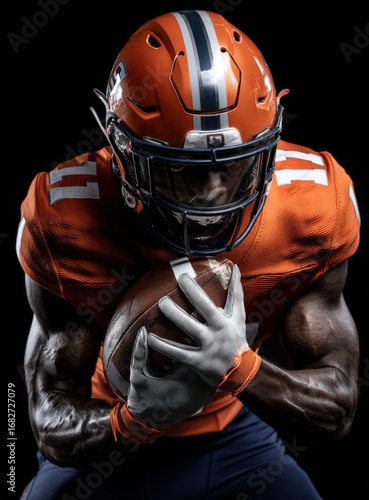 A football player in an orange uniform is holding a football