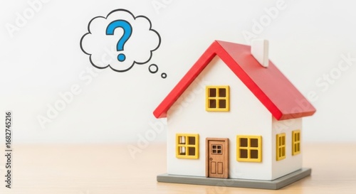 Miniature house with red roof and yellow windows has a question mark thought bubble above it model home