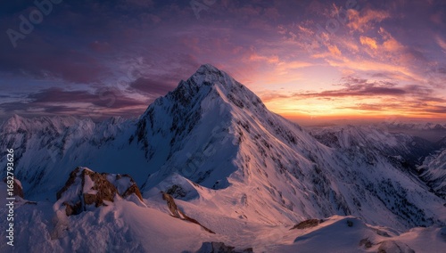 Majestic snow-capped peak at sunrise.  Vast mountain range panorama