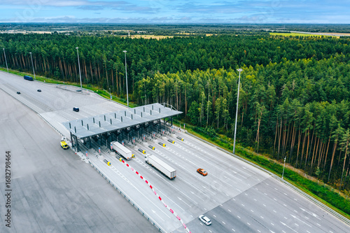 Aerial drone view on motorway with toll collection point, freeway toll booth. Checkpoint on the road. Car traffic transportation on multiple lanes highway road and toll collection gate